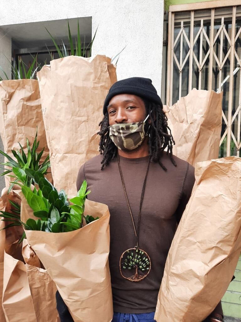 Louis Easton poses with wrapped plants before they are delivered